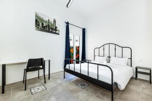 a bedroom with a bed and a desk and a chair at Arbutus Bed and Bar in Portimão