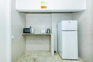 a kitchen with a refrigerator and a microwave at Arbutus Bed and Bar in Portimão