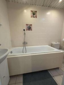 une salle de bain blanche avec une baignoire et un lavabo dans l'établissement Hotel Gryf, à Gryfice