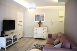 a living room with a couch and a tv at APARTAMENT TETRIS - CENTRUM - Garaż in Kielce