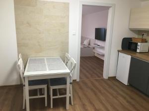 a kitchen and dining room with a table and chairs at Apartmány Zuberec 893 in Zuberec +5 photos
