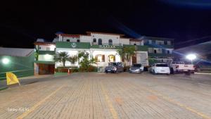 a parking lot in front of a building at night at Hotel Master in Salinas