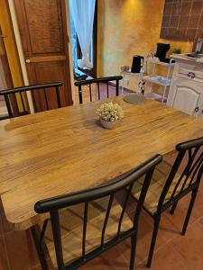 a wooden table with chairs and a bowl of flowers on it at The secret room in Pitigliano