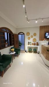 a living room with green chairs and a table at Hotel Master in Salinas