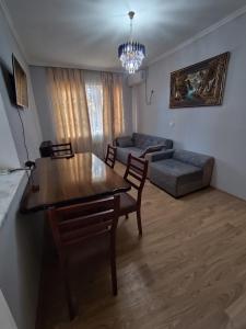 una sala de estar con una mesa y un sofá en ბინა appartement, en Kutaisi