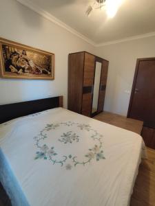1 dormitorio con 1 cama grande con motivos florales en ბინა appartement, en Kutaisi