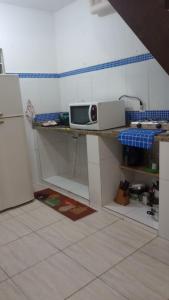 a kitchen with a microwave on a counter at Casa do sossego - conforto, praia, piscina in Maricá