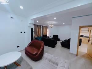 a living room with a couch and a table at Royal 3 Bedroom Apartment with 24hrs Power Supply, Wifi, Security and Fully Equipped Kitchen in Lekki