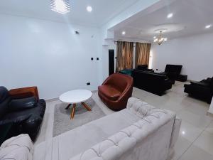 a living room with a couch and a table at Royal 3 Bedroom Apartment with 24hrs Power Supply, Wifi, Security and Fully Equipped Kitchen in Lekki