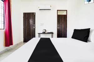 Una cama en blanco y negro en una habitación con ventanas. en Hotel O The Moon, en Bareilly 22 fotos más