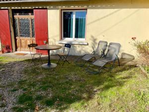 a group of chairs and a table in front of a house at COSY Dépendance proche Saint- Émilion in Le Fieu