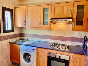 una cocina con estufa y lavadora en Calm Garden Retreat - Private Patio, BBQ, Pool Access & Free Breakfast, en Marrakech