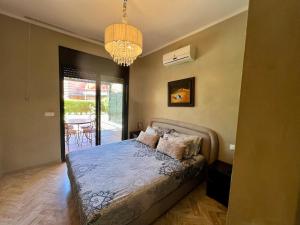 Un dormitorio con una cama y una lámpara de araña en Calm Garden Retreat - Private Patio, BBQ, Pool Access & Free Breakfast, en Marrakech 27 fotos más