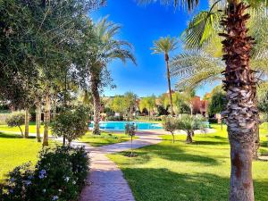 un complejo con piscina y palmeras en Calm Garden Retreat - Private Patio, BBQ, Pool Access & Free Breakfast, en Marrakech