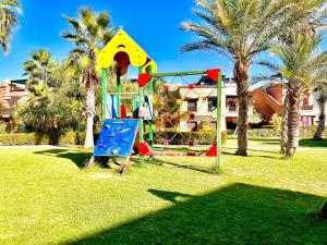 un patio de recreo en un parque con palmeras en Calm Garden Retreat - Private Patio, BBQ, Pool Access & Free Breakfast, en Marrakech