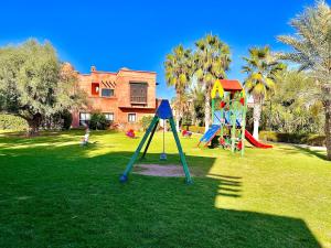 un parque con niños jugando en el parque infantil en Calm Garden Retreat - Private Patio, BBQ, Pool Access & Free Breakfast, en Marrakech