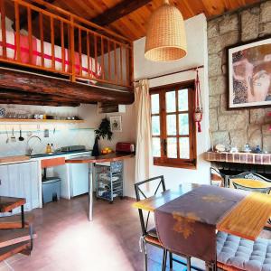 a kitchen with a table and a dining room at Cabaña de Madera el Roserar Parque Natural de Montseny in Montseny