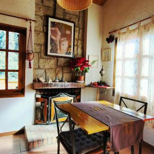 une salle à manger avec une table et une cheminée dans l'établissement Cabaña de Madera el Roserar Parque Natural de Montseny, à Montseny 28 autres photos