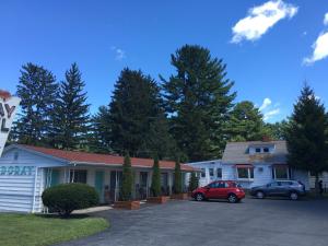 a house with two cars parked in a parking lot at Doray Motel Lake George in Lake George
