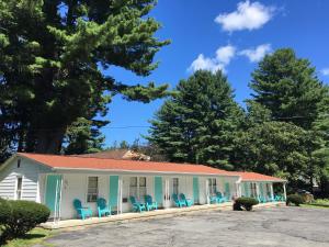 a house with blue chairs in front of it at Doray Motel Lake George in Lake George