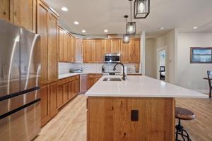 eine Küche mit Holzschränken und einer weißen Arbeitsplatte in der Unterkunft 110 Crane in Three Rivers