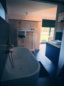 Un baño con bañera blanca en una habitación. en B&B De Geythoek, en Sijsele