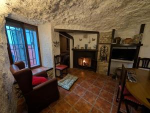 un salon avec cheminée dans un immeuble en pierre dans l'établissement Casa Rural Cueva El Sauce, à Pegalajar