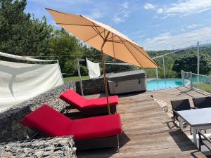 a patio with two red chairs and an umbrella at Erfurt Haus Paradies in Erfurt
