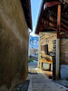 een steeg met een stenen gebouw met een balkon bij Maisonnette cosy montagne in La Garde