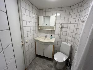 Un baño con lavabo, inodoro y espejo. en Hotell Strandvillan Orsa, en Orsa 38 fotos más