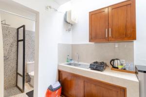 Una cocina con gabinetes de madera y un fregadero. en Taman Bali Homestay, en Sanur 24 fotos más