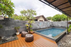 a swimming pool in the backyard of a house at Taman Bali Homestay Sanur in Sanur