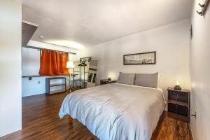 ein Schlafzimmer mit einem großen weißen Bett und Holzböden in der Unterkunft Inventor's Cottage 30 Night Minimum in Underwood