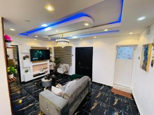 Una sala de estar con un sofá y un televisor en DreamBay Homes, en Isheri-Olofin
