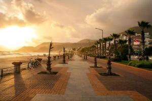 a street with palm trees and the beach at sunset at Salam Residence 2 - Ladies-Only Pool & Family Pools in Alanya