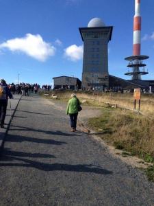 a group of people walking down a road with a lighthouse at Ferienhaeuser-Am-Eichenberg-Haus-1 in Blankenburg +3 photos