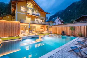 a house with a swimming pool in the backyard at AlpinSpa zur Post Apartment - Bergbahn im Sommer 2026 inklusive in Bad Gastein