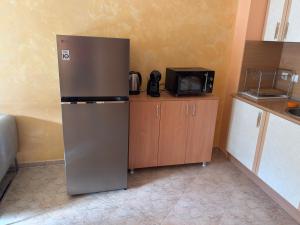 a stainless steel refrigerator in a kitchen with a microwave at Apartment 24 in Pamporovo +5 photos