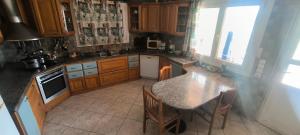 a kitchen with wooden cabinets and a table with chairs at Kounis Villa in Chalkida