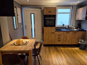 une cuisine avec une table en bois et une salle à manger dans l'établissement Stadtnah an der Förde 5703, à Flensbourg 5 autres photos