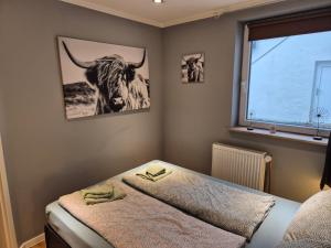 - une chambre dotée d'un lit avec une photo de taureau sur le mur dans l'établissement Stadtnah an der Förde 5703, à Flensbourg