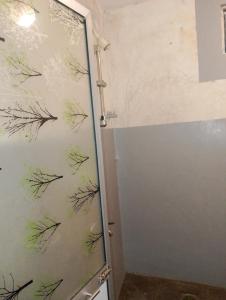 una ducha con una puerta de cristal con dibujos. en Sihe House, en Ahangama 28 fotos más