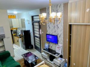 a living room with a tv on a stone wall at RENE haven in Nairobi
