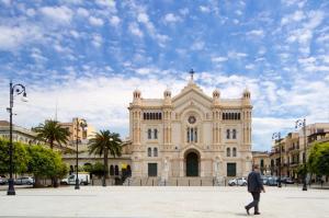 AltoRione في ريجّو دي كالابريا: رجل يمشي أمام مبنى كبير