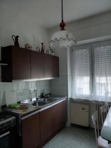 a kitchen with brown cabinets and a sink and a chandelier at Appartamento Beatrice in Pistoia