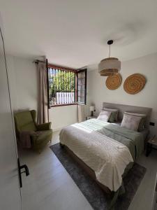 a bedroom with a bed and a chair and a window at Buganvilla Garden Puerto de la Cruz in Puerto de la Cruz