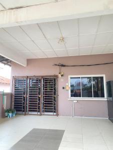 een kamer met een roze muur en een raam bij Pinggiran Bayu Homestay in Kuantan