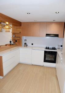 una cucina con banconi bianchi e armadi in legno di duplex bord de mer résidence restinga smir a Restinga Smir Altre 6 foto