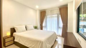 ein Schlafzimmer mit einem weißen Bett und einem Fenster in der Unterkunft Wins Apartment in Hanoi