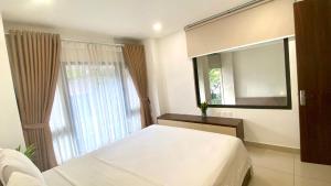 ein Schlafzimmer mit einem weißen Bett und einem Fenster in der Unterkunft Wins Apartment in Hanoi + 55 Fotos